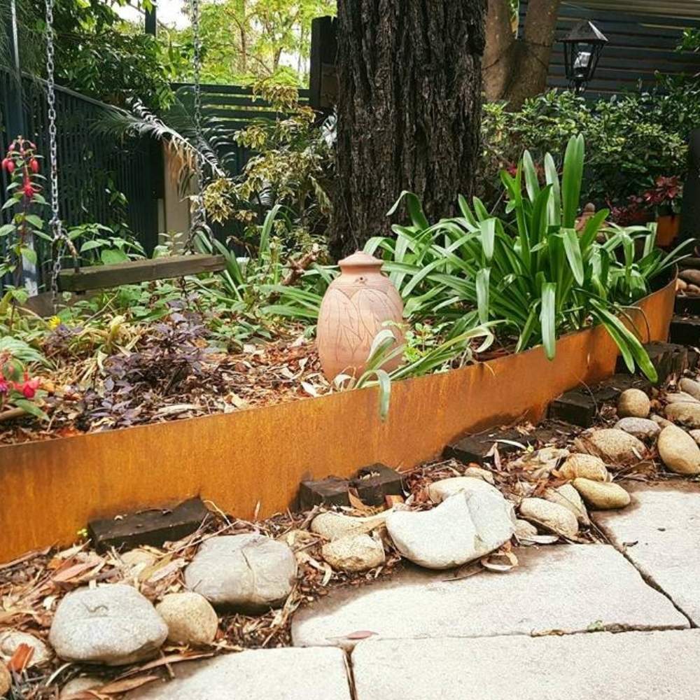 Corten steel garden edging with a weathered rust finish beside planting