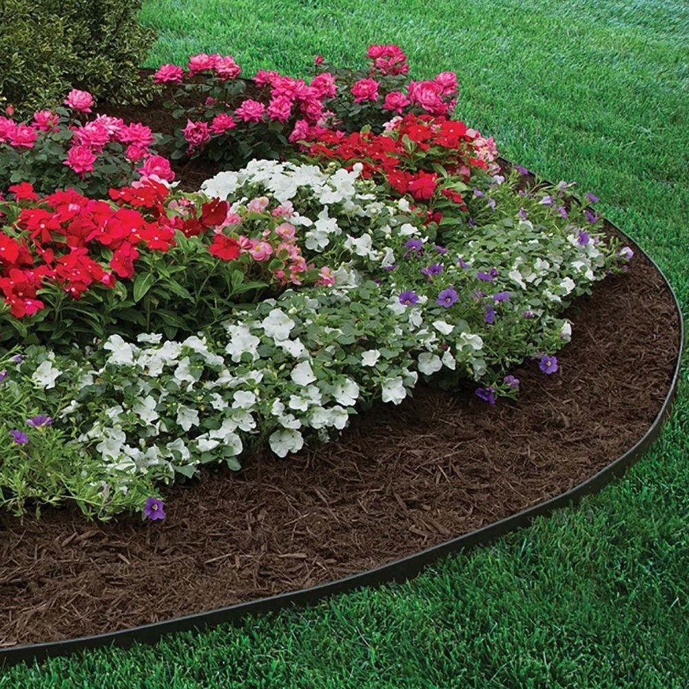 A curved flower bed edged against a lawn, the mulch held back by a clean garden edge